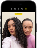 iPhone 18 Pro, Schwarz, Vorderseite, zwei Models posieren für die Kamera, die Center Stage Frontkamera wird gezeigt