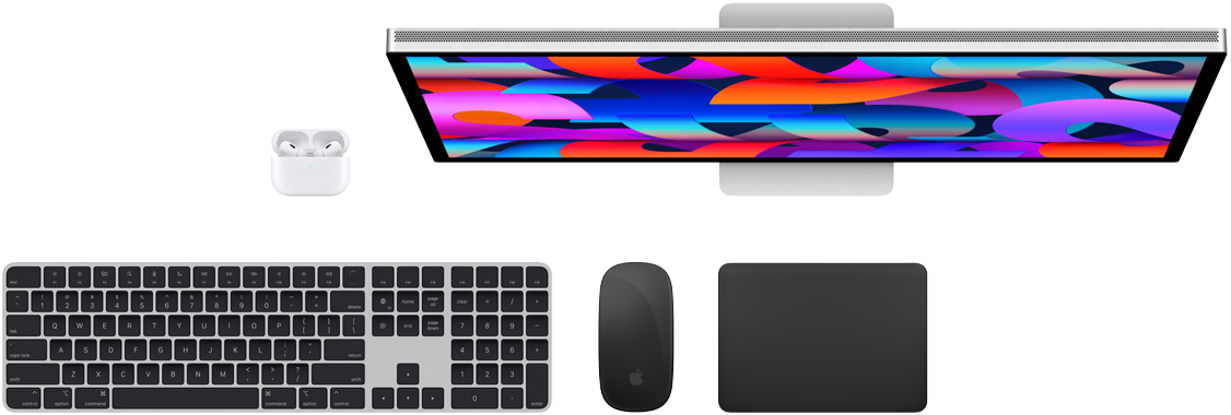 Draufsicht auf Mac Zubehör: Studio Display, AirPods, Magic Keyboard, Magic Mouse und Magic Trackpad